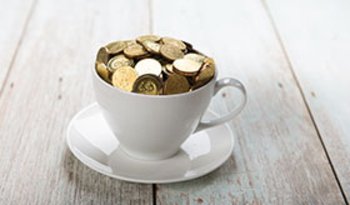 Tasse in weiß gefüllt mit Münzen